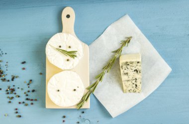 Yuvarlak camembert peyniri kalıp ahşap tahta üzerinde rosemary ile