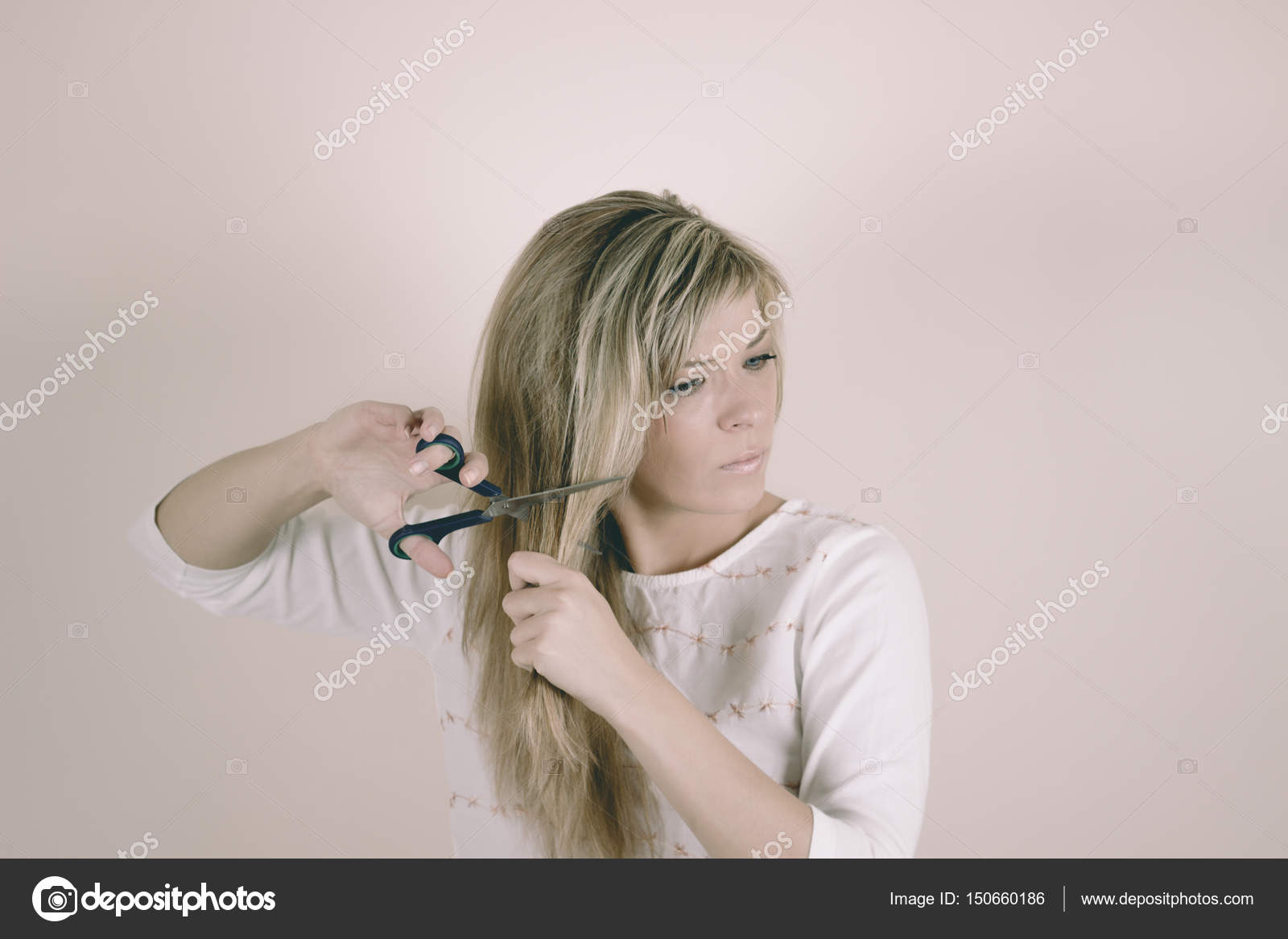 Angry Blonde Woman Cuts Her Hair With Scissors Stock Photo