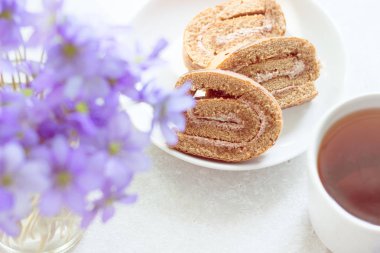 Lezzetli breakfast - bisküvi ile çay güneşli Menekşe bir arka plan üzerinde rulo