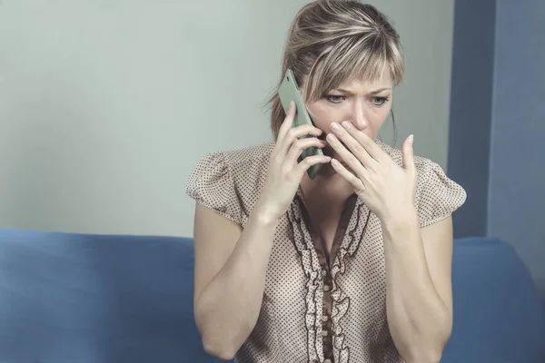 Genç bir kadın telefonla kötü haberler alıyor.