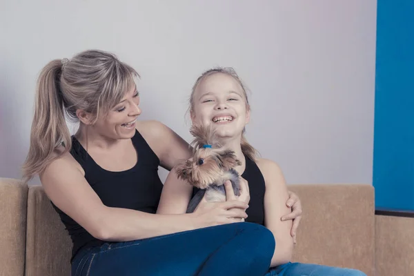 Pojęcie szczęśliwą rodzinę: śmiejąc się, Mama i Córka, grając z psem rasy Yorkshire terrier — Zdjęcie stockowe