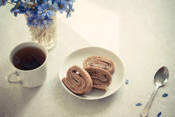 Délicieux petit déjeuner - petit pain de biscuits au thé noir sur fond de violettes ensoleillées — Photo