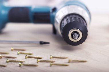 Akülü tornavida ya da matkap ve ahşap arka plan üzerindeki