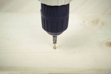 Birisi bir vida ahşap yüzey içine tornavida ile dalga geçiyor. DIY kavramı