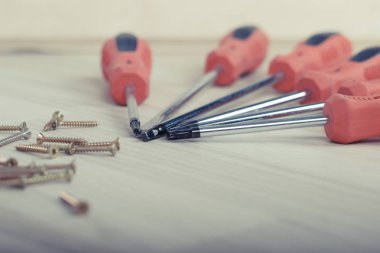 Tornavida ve vidalar ahşap arka plan üzerinde bir dizi