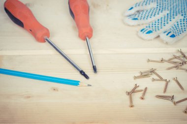 Tornavida ve vidalar ahşap arka plan üzerinde bir dizi