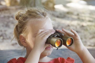 Dürbün ile güneşli yaz gününde komik küçük kız