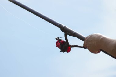 Balıkçı bir balık yakalar. Eller el closeup bir iplik çubuk ile balıkçı. Balıkçılık reel spin