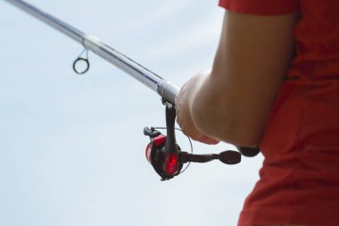 Balıkçı bir balık yakalar. Eller el closeup bir iplik çubuk ile balıkçı. Balıkçılık reel spin