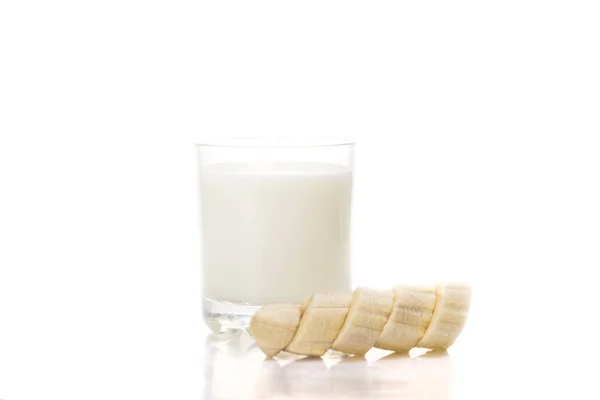 Segelas susu dingin dengan pisang terisolasi di atas putih — Stok Foto
