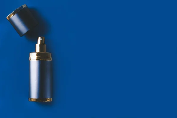 Botella de perfume de hombre sobre fondo azul oscuro con espacio para copiar —  Fotos de Stock