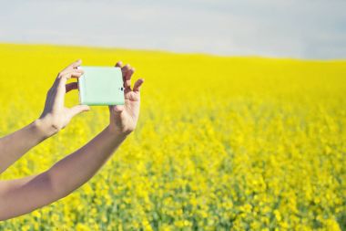 Teknoloji, yaz tatili, tatil ve insanlar kavramı - kadın alarak fotoğraf veya selfie yanında tecavüz sahada smartphone.