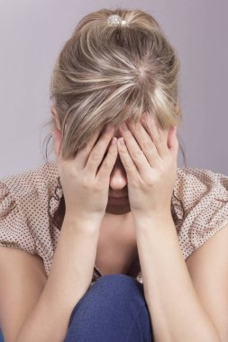 Kanepede oturan ve kafasını onun elinde tutan bir üzgün kadın