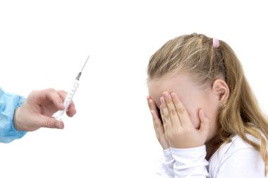 Kız beyaz izole doktorun ofisinde enjeksiyonları korkuyor.