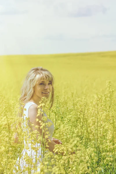 Женщина с длинными волосами, желтое рапсовое поле с канолой наслаждается природой и солнечным светом . — стоковое фото