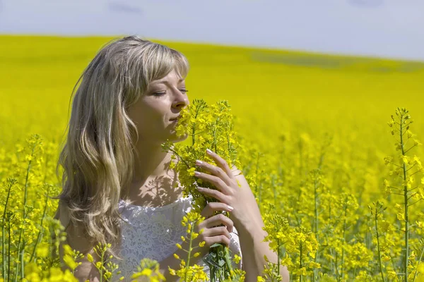 Мечтательная женщина на рапсовом поле с букетом мечтает и наслаждается природой . — стоковое фото