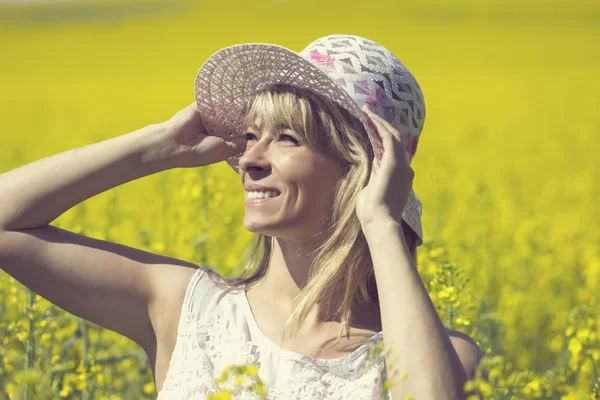 Молодая женщина в шляпе наслаждается летом на поле изнасилования — стоковое фото
