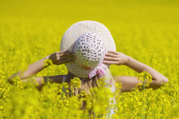 Mulher feliz desfrutando a vida no campo com flores. Natureza beleza e campo colorido com estupro. Estilo de vida exterior. Conceito de liberdade. Mulher no campo de verão . — Fotografia de Stock