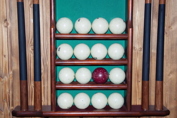 Billiard balls lie on the shelves, cue storage and a set of billiards. — Stock Photo, Image