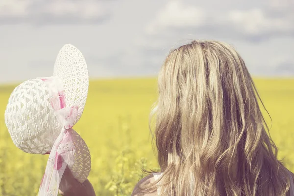 Mulher feliz desfrutando a vida no campo com flores. Natureza beleza e campo colorido com estupro. Estilo de vida exterior. Conceito de liberdade. Mulher no campo de verão . — Fotografia de Stock