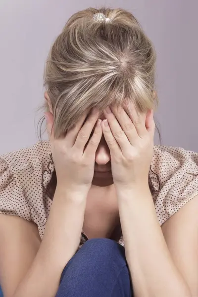 Kanepede oturan ve kafasını onun elinde tutan bir üzgün kadın