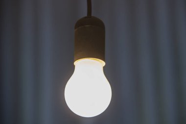 Yanan ampul tavandan asılı.