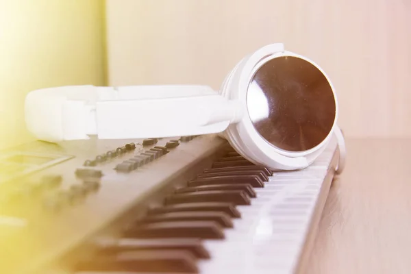 Наушники на клавиатуре музыкального синтезатора. Наушники на электронном пианино . — стоковое фото