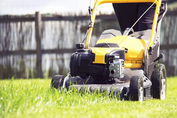 Lawn mower cutting green grass in backyard, garden service. — Stock Photo, Image