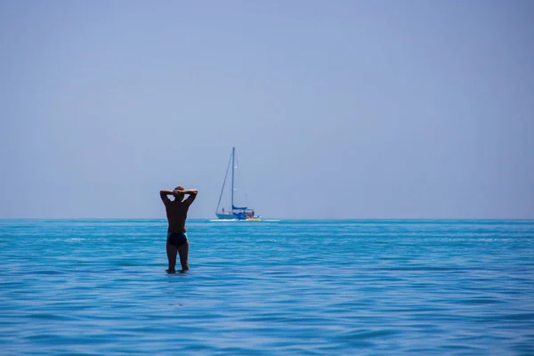 Silueta de un hombre en el mar contra un yate . — Foto de Stock