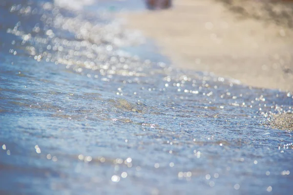 샌디 비치 (Sandy Beach) 에 있는 푸른 바다의 부드러운 물결. 백 그라운드. 선택적 초점. — 스톡 사진