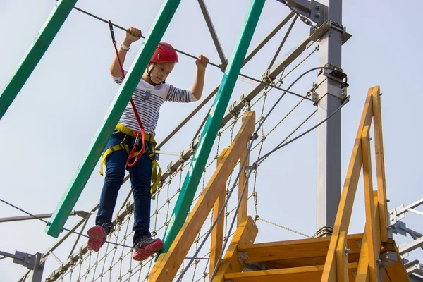 Menina escalando em um curso de cordas ao ar livre . — Fotografia de Stock