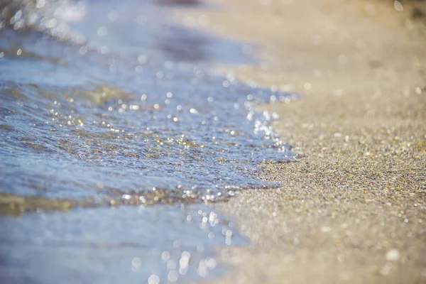 샌디 비치 (Sandy Beach) 에 있는 푸른 바다의 부드러운 물결. 백 그라운드. 선택적 초점. — 스톡 사진