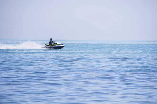 Jetbike biezen op de golven van de zee met grote snelheid dus vonken vliegen. — Stockfoto