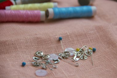 Pimleri ve keten bir arka plan üzerinde dikiş için düğmeleri.