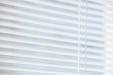 Arka plan olarak yatay beyaz güneşlikler.