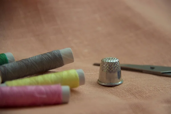 Kit de couture : fil multicolore, dé à coudre, ciseaux sur toile de lin . — Photo