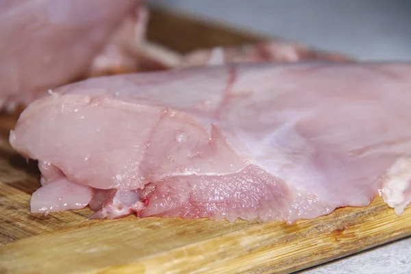 Filé de frango cru no fundo de madeira . — Fotografia de Stock