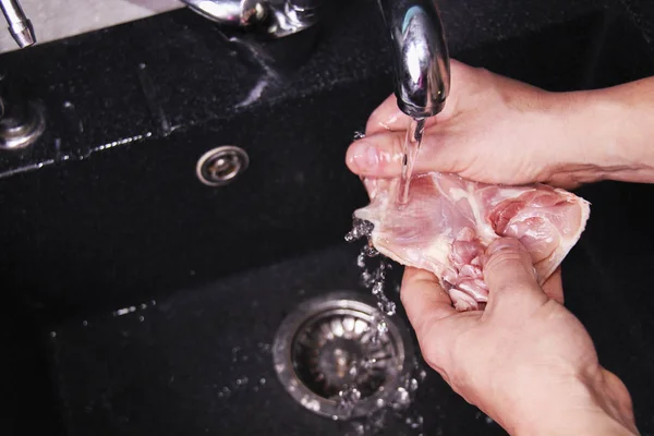 Las manos del hombre lavando y limpiando las alas de pollo en el fregadero de la cocina . — Foto de Stock