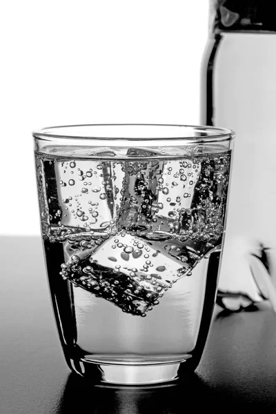Bicchiere Acqua Fredda Con Cubetti Ghiaccio Bottiglia Sullo Sfondo — Foto Stock