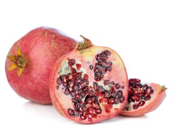 Tohumları beyaz arka planda gösteren bir nar meyvesinin yakın plan çekimi.