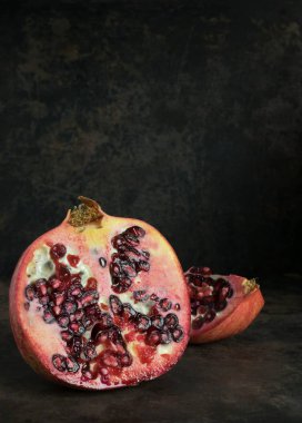 Nar meyvesinin koyu kırsal bir zemin üzerindeki düşük hafif görüntüsü ve metin için kopyalama alanı