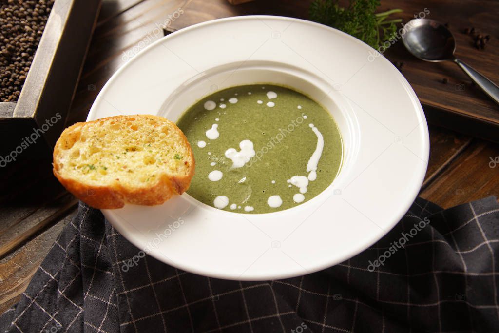 Spinach soup on wooden table