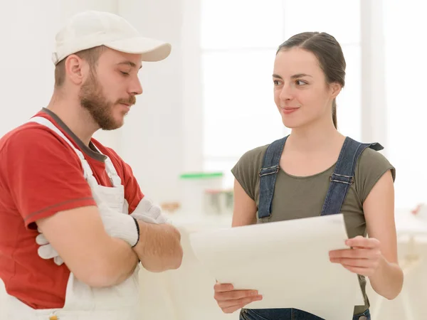 Bauunternehmer bespricht Pläne mit Frau im Zimmer — Stockfoto