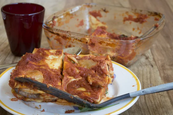 Portion of lasagna with empty baking-pan — Stock Photo, Image