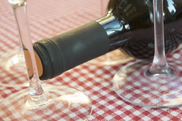 Wijnfles gelegd tussen kristallen glazen — Stockfoto