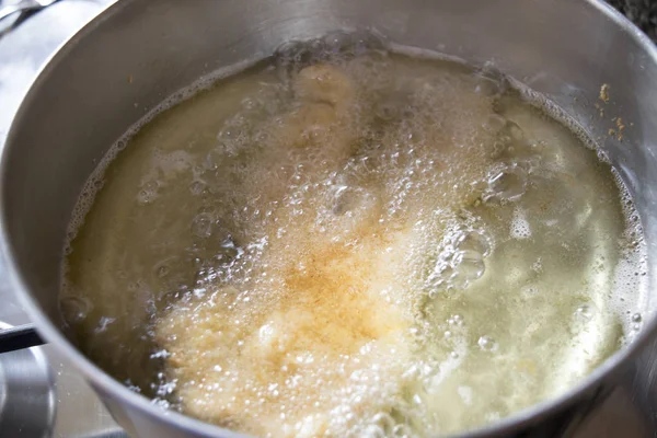 Escalope de dinde pendant la friture dans l'huile bouillante — Photo