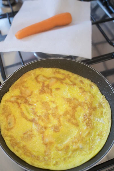 Omelette dans une casserole avec près d'une carotte — Photo