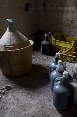 Eski bir mahzende yaşlı demijohm ve şarap şişeler
