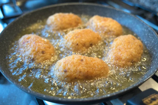 Rice croquettes frying in olive oil — Stock Photo, Image