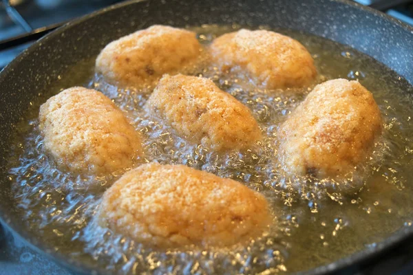 Croquetes de arroz fritando em azeite — Fotografia de Stock